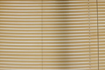 Obraz premium Full Frame Of Light Brown Window Blinds Creating Pattern Of Bright Lines And Shadows