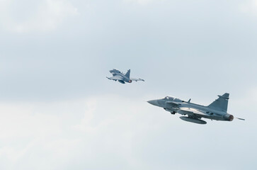 Two fighter jets fly through the sky on technology background