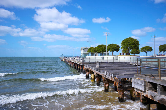 Fototapeta Serene seaside pier during sunny day with clear blue skies