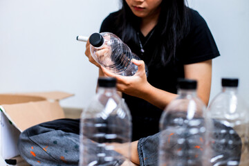 Young Woman Drawing On Plastic Bottle For DIY