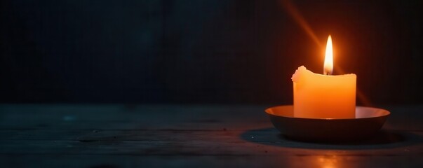 Burning candle flame illuminates darkness, somber mood, image, stock