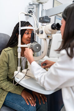 Optician examining patient's eyesight with slit lamp biomicroscope