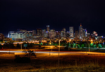 Dramatic night view of the Denver, Colorado skyline illuminated by colorful fireworks bursting in the sky, celebrating a festive event over the city&rsquo;s iconic downtown buildings.