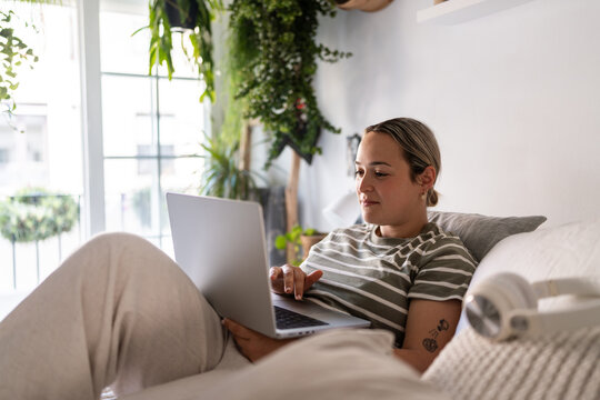 Young Woman Working From Home on Laptop in Living Room