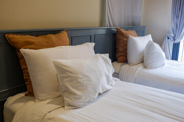 Hotel room scene with bed pillows and lamp on table,White soft pillows on bed,contemporary,Space for text.