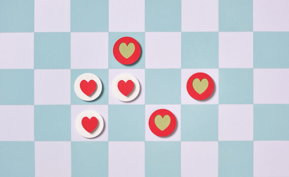 Colorful heart-shaped symbols are arranged on a checkered background