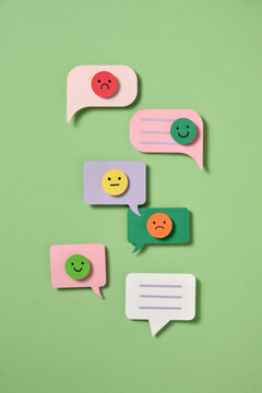 Paper cut-out speech bubbles with emoji faces range of emotions