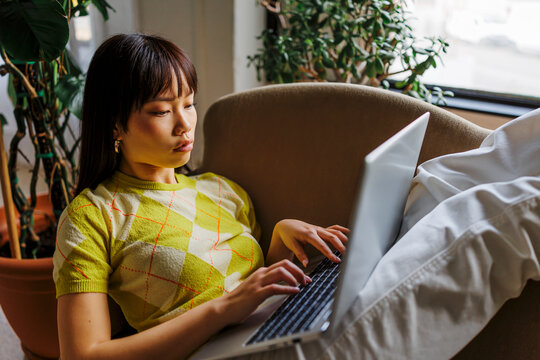 Woman studying remotely from home using laptop