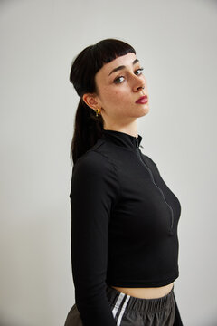 Model poses in minimalist studio wearing stylish black outfit