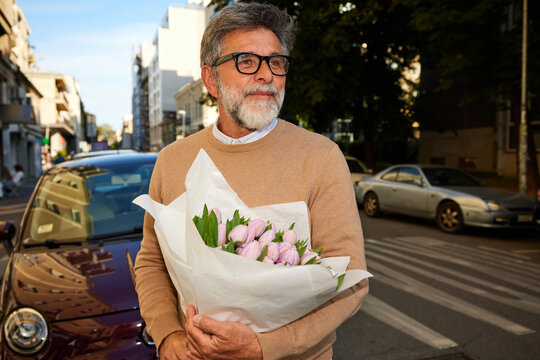 Man walks with a bouquet of flowers in town