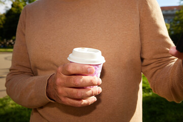 Anonymous man holding a cup of takeaway coffee
