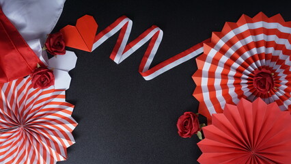 Independence Day Indonesia banner mockup with Indonesia flag, , Indonesia flag color paper fans, ribbons, and decoration isolated on black background