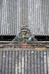 Intricate dragon sculpture atop traditional roof in DuJiangYan,