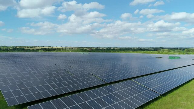 Aerial drone view of photovoltaic solar power plant station renewable energy electricity Newark England UK sub station pylons 