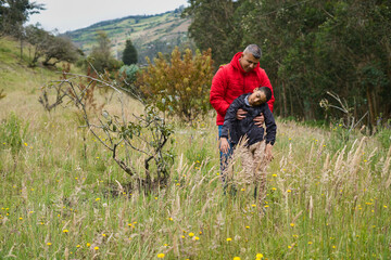 Father helping his fainting son in the countryside
