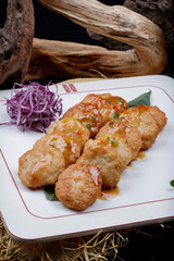 Fried shrimp and water chestnut cakes are placed on a linen mat