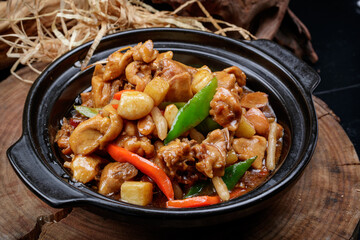 Garlic chicken in a black casserole placed on a camphorwood chopping board