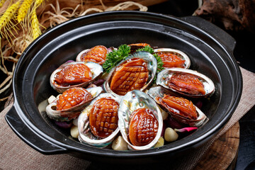 Garlic baked casserole with fresh abalone placed on a linen mat