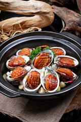 Garlic baked casserole with fresh abalone placed on a linen mat