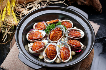 Garlic baked casserole with fresh abalone placed on a linen mat
