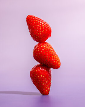 Stacked strawberries create a vibrant visual on a violet background