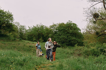 Active middle age woman walking outdoors with friends in green nature, enjoying health, wellness,...
