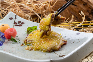 Golden fried pork cutlet in a cyan porcelain plate placed on a linen mat