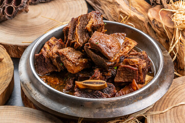 Iron pot braised pork ribs placed on a camphorwood chopping board