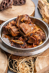 Iron pot braised pork ribs placed on a camphorwood chopping board