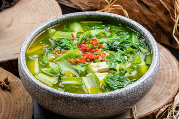 Braised Chinese cabbage and tofu in a porcelain bowl placed on a camphorwood chopping board