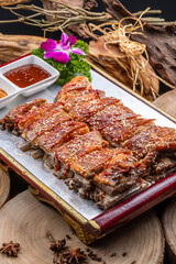 Mongolian grilled lamb chops in a red lacquer plate on a camphorwood chopping board