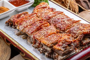 Mongolian grilled lamb chops in a red lacquer plate on a camphorwood chopping board