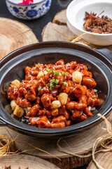 Braised garlic chicken in a pot on a camphorwood chopping board