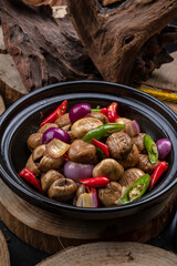 Black casserole with shallots, fresh mushrooms, rice and peppers