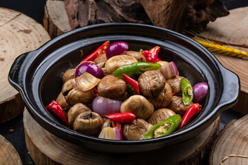 Black casserole with shallots, fresh mushrooms, rice and peppers