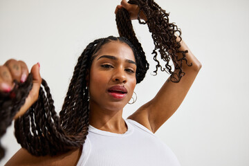 Stylish woman showcasing her long twisted hair indoors