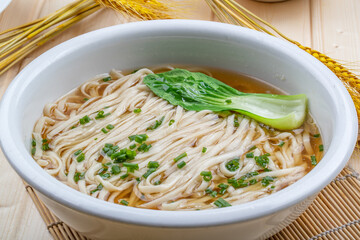 Vegetarian clear soup noodles in a white porcelain bowl