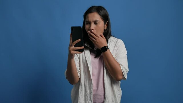 Young Asian woman showing confused face when looking at her phone