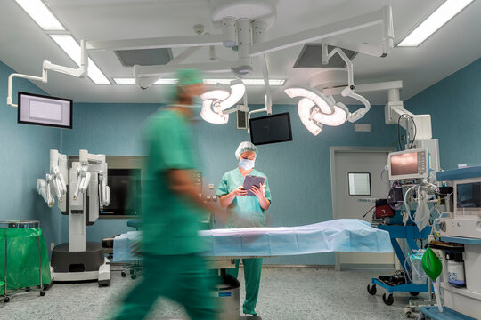 Surgeons preparing modern operating room for surgery.