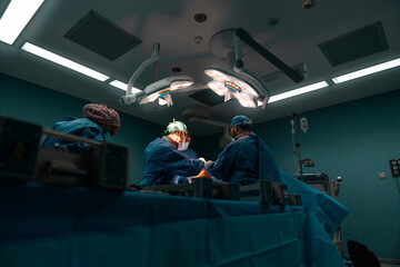 Surgeons in a surgery under bright surgical lights in a operating room