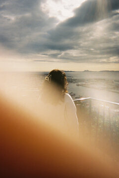 Girl looking at the sea with a finger accidentally blocking the lens
