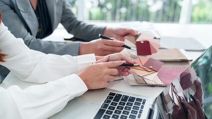 Interior Design Team Hands Selecting Color Palette Swatches for Home Renovation Project with Fabric...