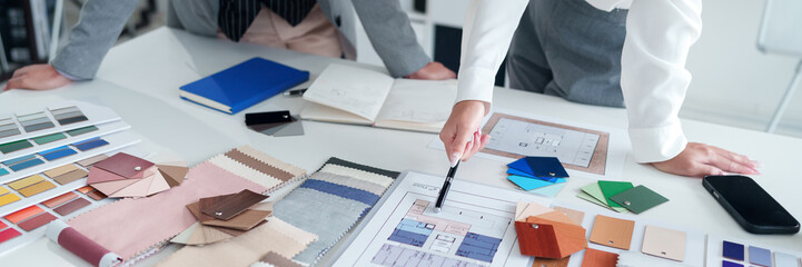 Interior Design Meeting with Asian Adult Architects Reviewing Blueprints Color Schemes and Material Samples for Home Renovation Project and Selection Process