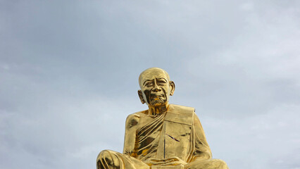 Majestic golden statue of revered monk Luang Pu Tim at Wat Lahan Rai in Rayong, Thailand, captured...