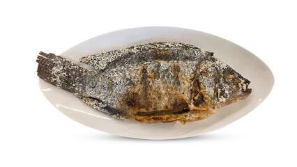 Whole tilapia grilled with a salt crust and stuffed with lemongrass, served on a white plate as a...