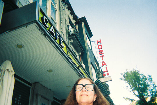 Tourist woman in front of old hostel and caf&eacute; 
