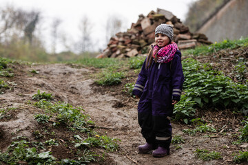 Naklejka premium Smiling girl exploring nature trail near brick pile