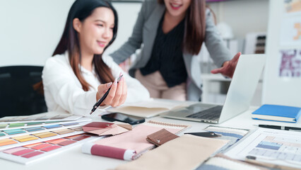 Asian Interior Designers Discussing Fabric and Color Palette for Modern House Design Project Asian Women Architects Meeting and Planning Interior Decor on Laptop