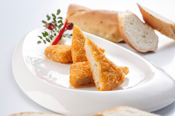 Deep-fried fresh shrimp cakes cut into pieces on a white porcelain plate