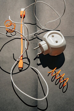 Various charging cables and a plug on a dark surface